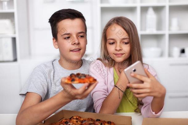 年幼的少年男女迷人的一自拍照和他们的pizz一采用指已提到的人厨房