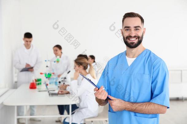 肖像关于医学的学生和有纸夹的笔记板采用科学的劳动
