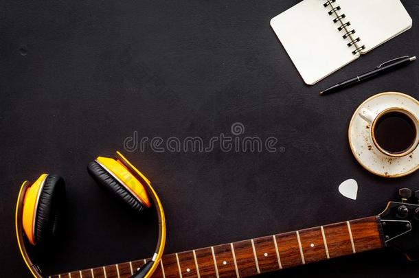 音乐家使工作位和吉他,耳机,笔记簿和咖啡豆