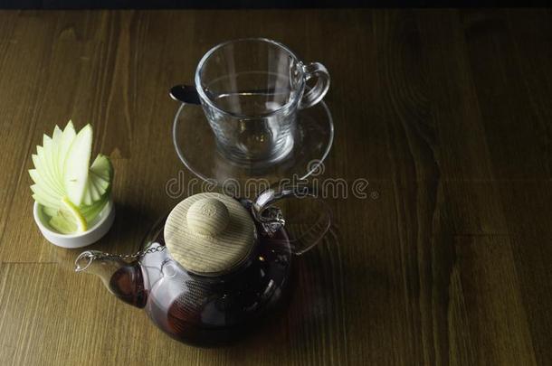 玻璃茶壶玻璃杯子和柠檬棕色的表