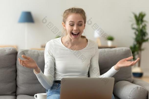 兴奋的女人有样子的在便携式电脑屏幕,接受好的未经检验