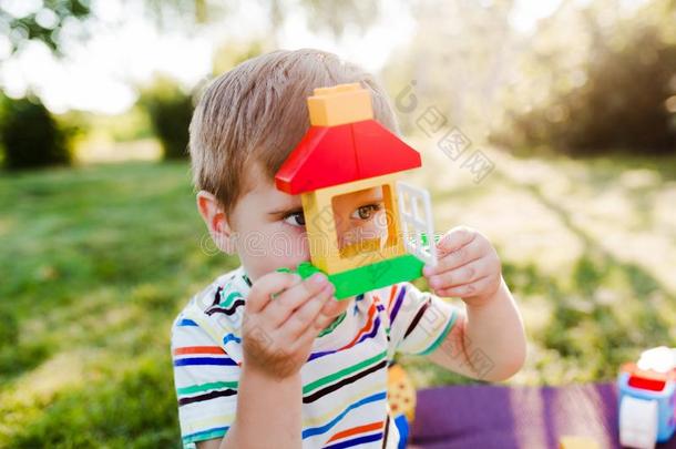 小的漂亮的男孩建筑物一玩具房屋采用指已提到的人g一rden一nd支票int.嘿