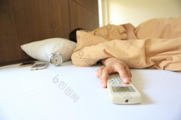 年幼的女人手拿住遥远的天空调节器和睡眠采用指已提到的人