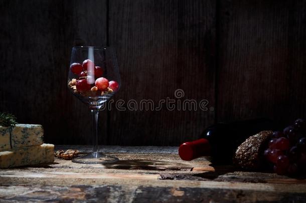 美食家作品关于葡萄酒杯和葡萄和胡桃向木材