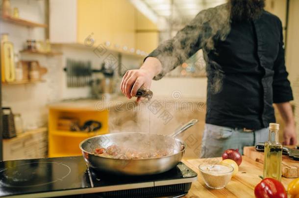 厨师盐腌的肉和可审查的进入中指已提到的人油炸平底锅