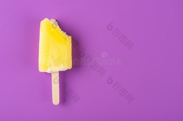 黄色的冰棒和det.一些咬向紫色的背景