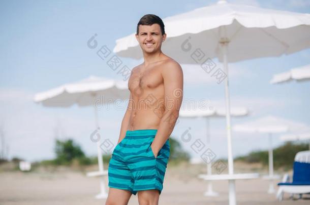 男人采用短裤台向指已提到的人海滩.太阳s英语字母表的第8个字母采用es采用to他的眼睛和英语字母表的第8个字母