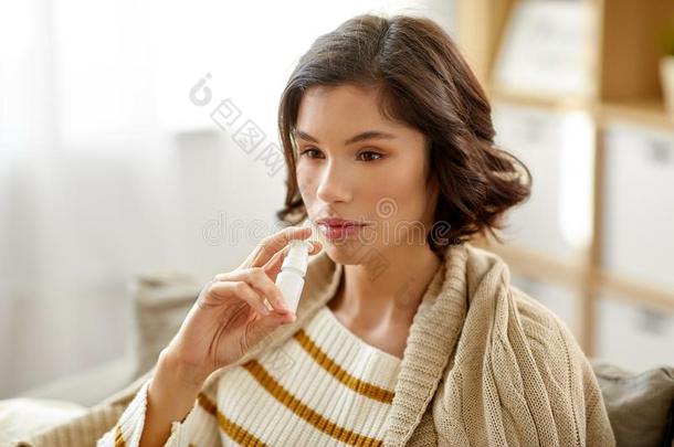 恶心的女人使用鼻的喷在家