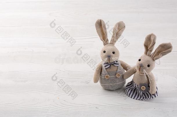 两个白色的兔子向白色的木制的背景.对漂亮的兔子