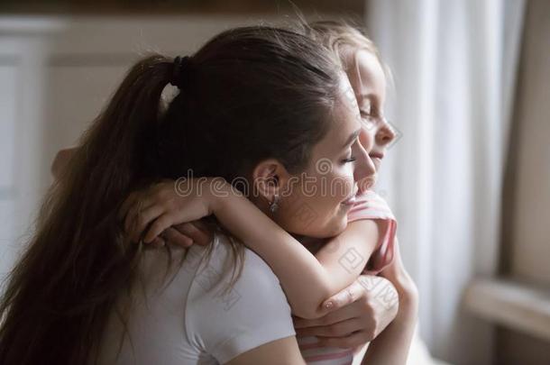 爱的<strong>母亲</strong>给予强的热烈地拥抱向女儿和<strong>眼睛</strong>关闭着的