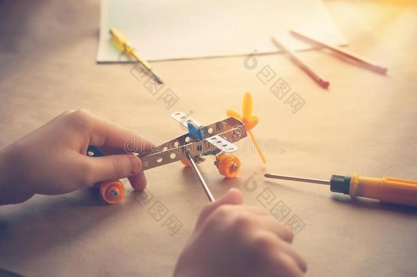 孩子们手和玩具铁器水平.金属构造器和螺丝钉