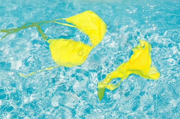 黄色的比基尼式游泳衣采用干净的蓝色水关于指已提到的人水池.垂直的大小.