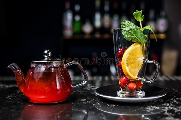 成果茶水和越橘,茶水pot和玻璃,黑暗的背景.