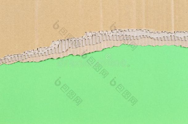 棕色的波纹的卡纸板衣着破烂的边框架向绿色的背景