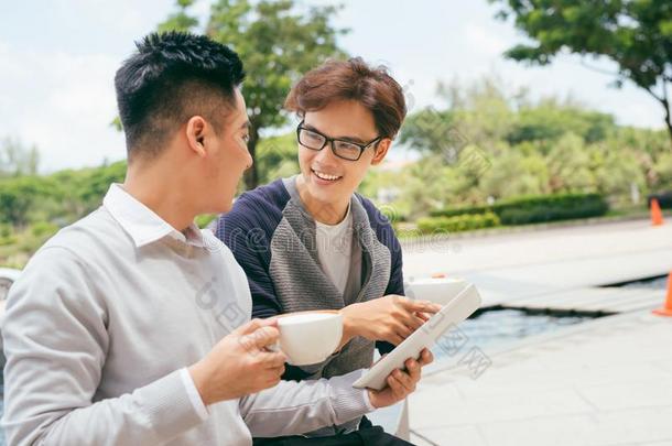 两个人使用碑计算机互联网,亚洲人朋友家伙sitting-room起居室