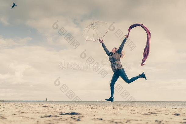 幸福的女人用于跳跃的和围巾向海滩