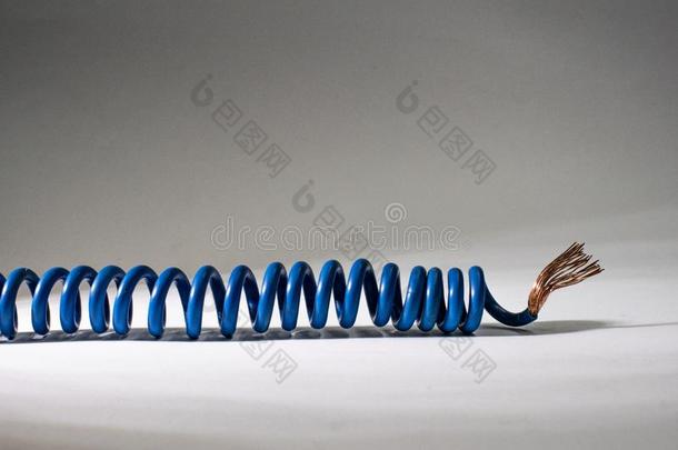 蓝色缆绳反常的向白色的背景.用电的绝缘的金属丝