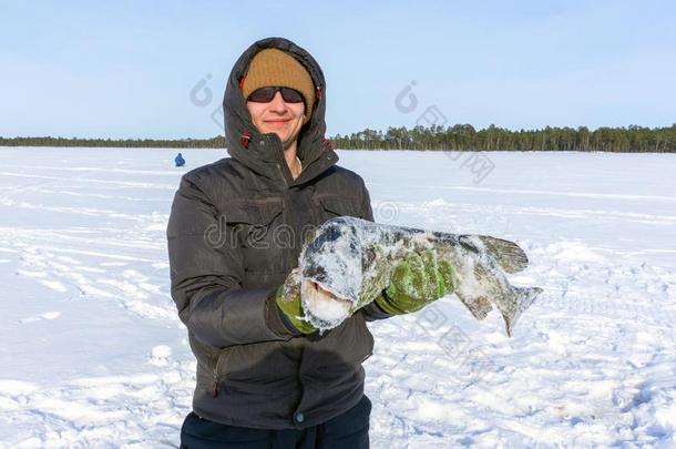 年幼的男人佃户租种的土地鱼赶上一大的长矛冰鱼ing