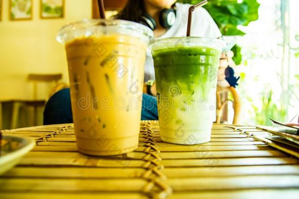冰冷的日本抹茶拿铁咖啡和冰冷的咖啡豆采用塑料制品玻璃