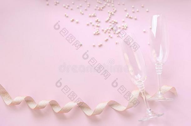 香槟酒眼镜和分散的白色的珍珠和金色的带子向