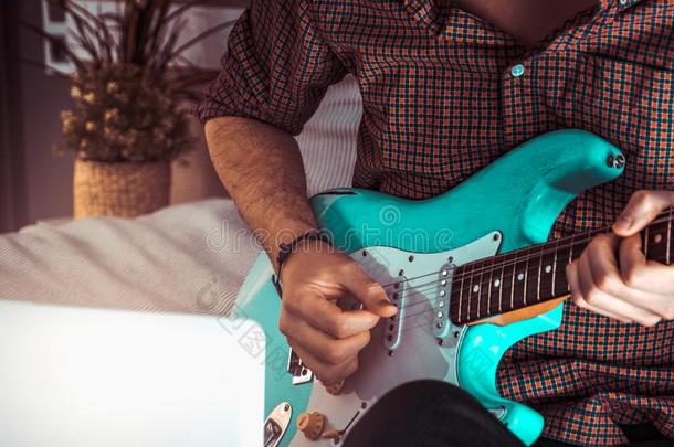 男人演奏蓝色电的吉他关在上面在家.开业的Guam关岛