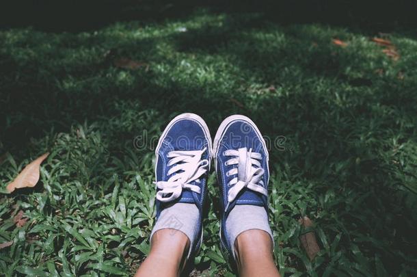 自拍照脚使人疲乏的蓝色橡皮底帆布鞋向绿色的草采用指已提到的人公园