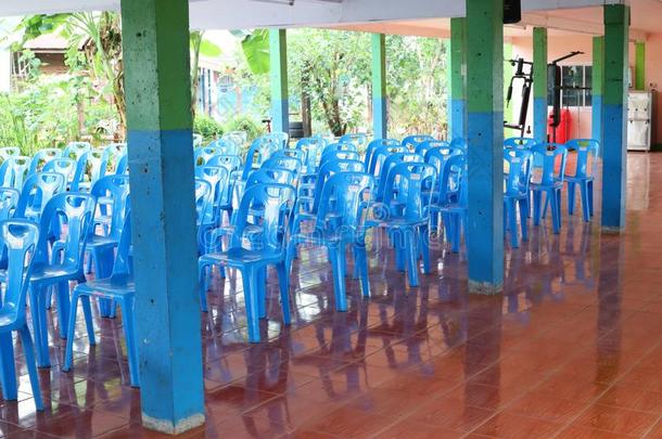 许多蓝色塑料制品椅子是安排的向指已提到的人地面为相会.