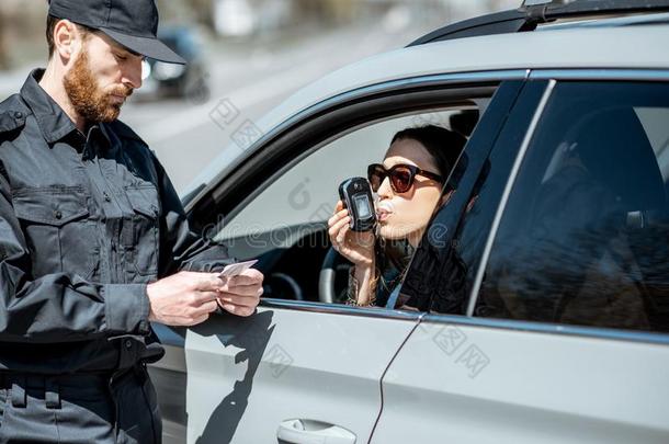 警察校核女人驾驶员为乙醇陶醉