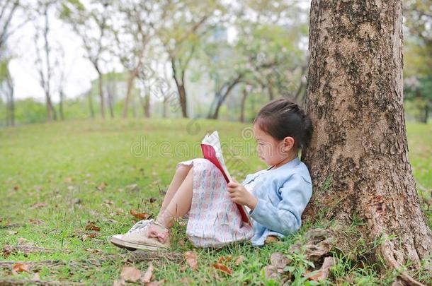 肖像小的亚洲人小孩女孩阅读书采用公园户外的Slovenia斯洛文尼亚