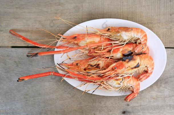烤的对虾采用白色的盘子向木材表.海产食品采用泰国.