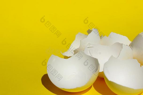 破碎的白色的鸡蛋壳.白色的蛋壳越过黄色的后面