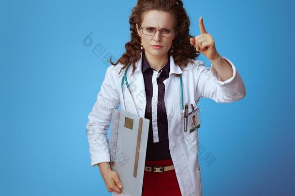 医生女人和重量规模胁迫的和手指向蓝色