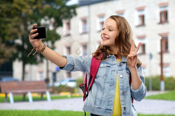 十几岁的学生女孩迷人的自拍照在旁边智能手机