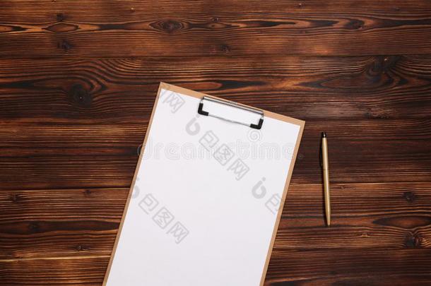 有纸夹的笔记板和白色的纸向木材背景.顶看法