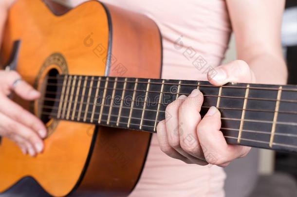 特写镜头关于年幼的女人手演奏听觉的吉他