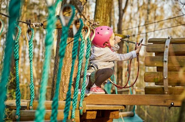值得崇拜的小的女孩采用头盔采用粗绳公园采用森林
