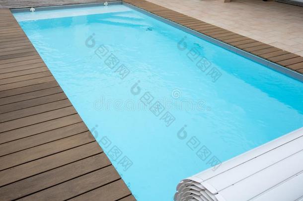 蓝色游泳水池和柚木木材铺地板采用家花园夏