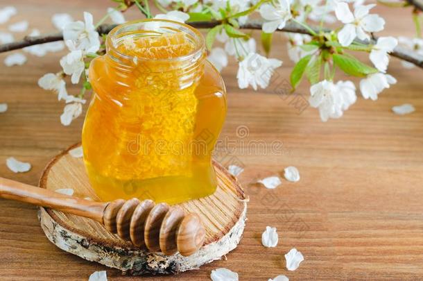 蜂蜜罐子和蜂窝和蜂蜜浸渍者向木制的背景wickets三柱门