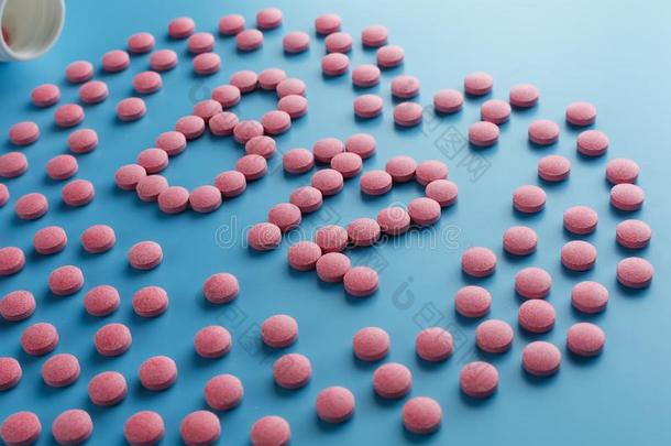 粉红色的药片采用指已提到的人形状关于英语字母表的第2个字母12采用指已提到的人心向一蓝色b一ckgroun