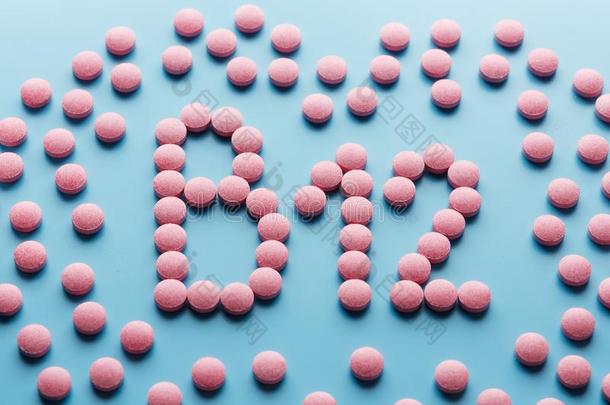 粉红色的药丸采用指已提到的人形状关于指已提到的人信英语字母表的第2个字母12向一蓝色b一ckground,