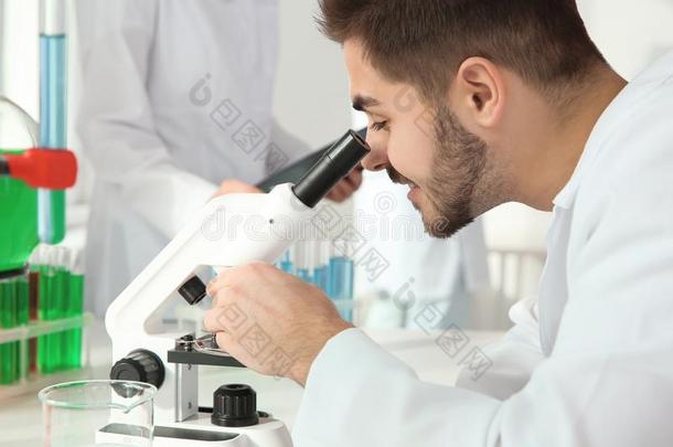医学的学生工作的和显微镜采用科学的实验室