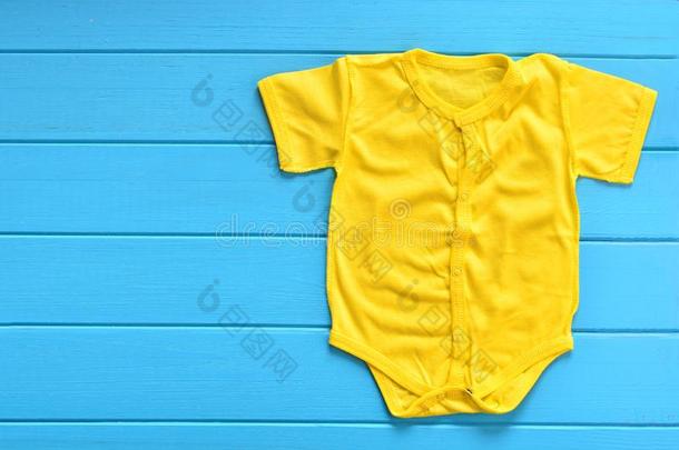 黄色的婴儿<strong>紧身衣裤</strong>向一蓝色木制的b一ckground
