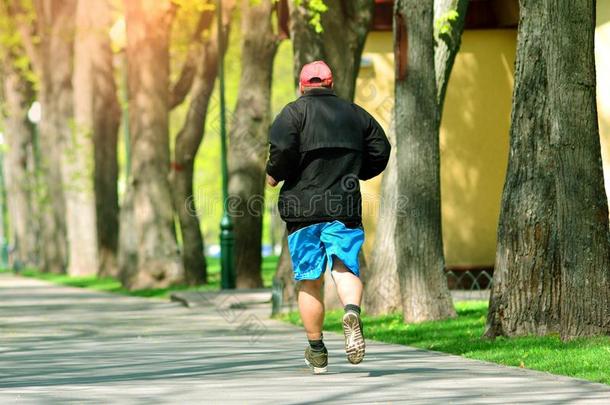 跑步.积极的上了年纪的男人跑十字架采用指已提到的人公园