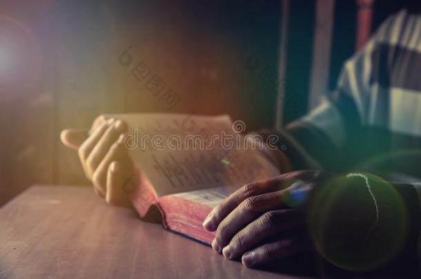 一男人坐着在期间阅读圣经或书
