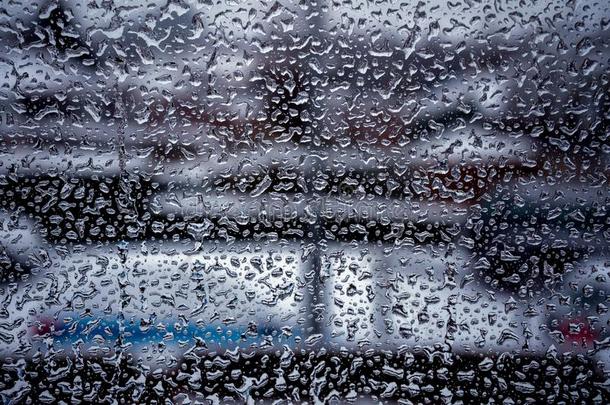雨落下向窗玻璃表面和多云的背景