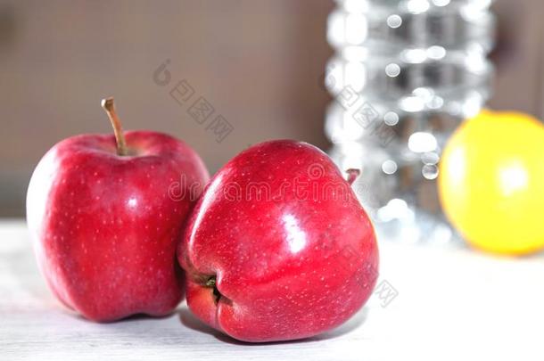 两个红色的苹果向一白色的t一ble,紧接在后的向一瓶子关于w一ter