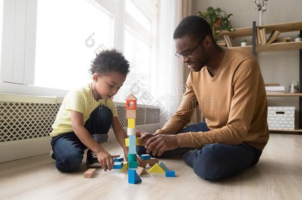 父亲和儿子一次向地面比赛和玩具赛跑者起跑时脚底所撑的木块