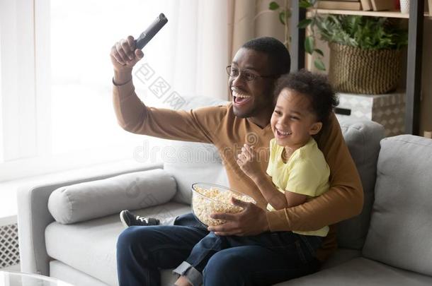 兴奋的非洲的父亲和儿子观察<strong>足球游戏</strong>向television电视机