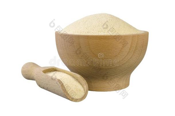 粗粒小麦粉采用木制的碗和铲隔离的向白色的背景.