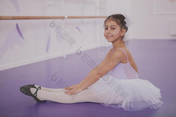 迷人的年幼的女孩芭蕾舞女演员锻炼在跳舞学校